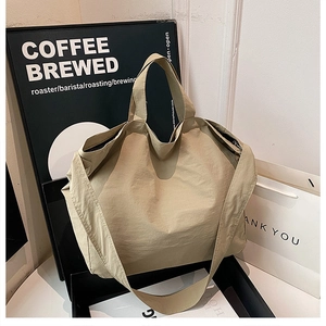 Dettaglio ravvicinato della grande borsa tote in tela con manici robusti e tracolla larga