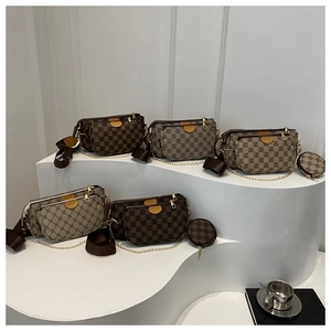 Detailed macro view of checkered pattern shoulder bag with golden chain and straps
