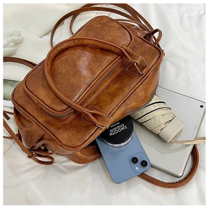 Detail showing high-capacity brown vintage PU leather bag with smooth oil wax texture