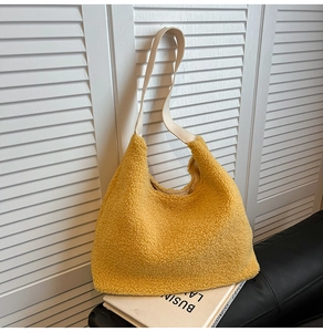 Detail of soft yellow faux shearling tote bag with contrasting cream shoulder strap