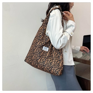 Close-up of leopard print tote bag worn with a blazer for a stylish commuter outfit
