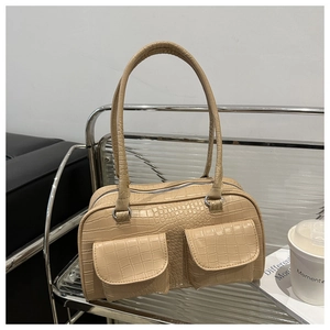 Close-up of beige crocodile pattern tote bag with double pockets and silver buckles
