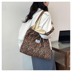 Fashionable leopard print tote bag shown on model in a minimalist indoor setting