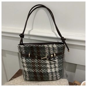 Détail du sac seau en laine vintage avec motif à carreaux vert et marron et lanière en cuir