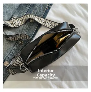 Détail de la capacité intérieure du sac bandoulière noir avec sangle à motifs
