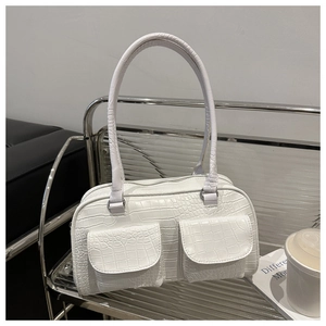 Detail of white crocodile texture handbag with dual front pockets and long handles
