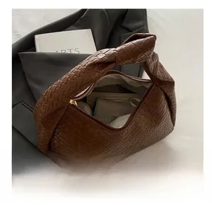 Detailed view of the brown woven tote bag's spacious interior and knotted handle