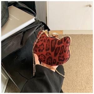 Detail view of mini leopard print cat-shaped bag with gold chain and gem closure