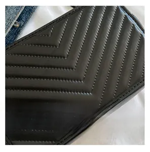 Gros plan du cuir synthétique matelassé noir avec coutures en V sur un sac élégant