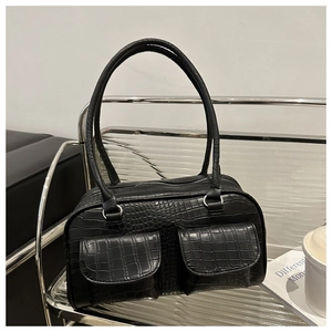 Detail of black crocodile pattern faux leather handbag with dual front flap pockets