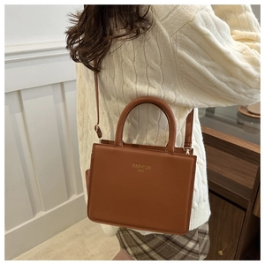 Brown rectangular fashion bag shown with knit sweater and plaid skirt for casual style