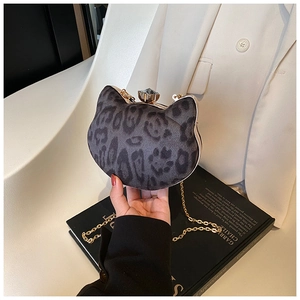 Detail of leopard print cat-shaped bag with gold jewel clasp and metal chain strap