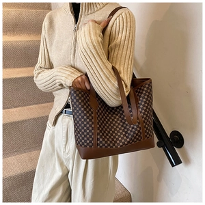 Retro tote bag detail featuring vintage geometric patterns and premium brown leather straps