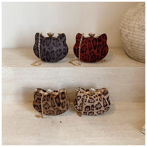 Detail view of mini leopard print cat head evening bags with gold chains and crystal clasps