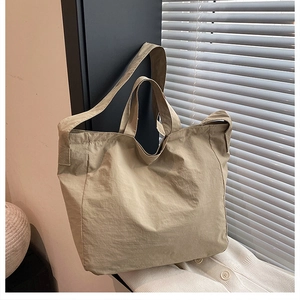 Dettaglio della borsa tote kaki con trama in nylon plissettato e tracolle versatili