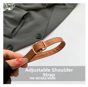 Detailed macro view of adjustable brown leather strap with polished golden buckle