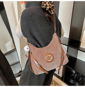 Détail d'un sac cabas en velours côtelé marron clair avec logo M et charme peluche