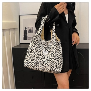 Detail view of large leopard print tote bag styled with a professional black blazer
