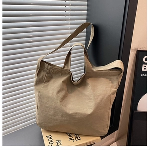 Dettaglio della borsa tote kaki minimalista che mostra la texture e i doppi manici