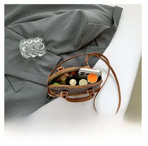 Internal storage of leopard print handbag with essentials like phone and perfume