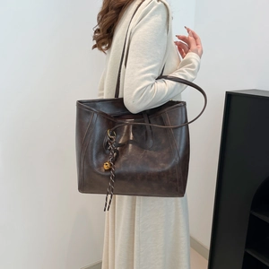 French vintage brown leather tote bag with long straps and gold bell charm detail