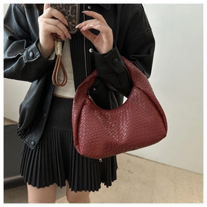 Detailed view of dark red woven leather hobo bag texture and crescent moon design