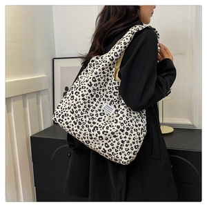 Detail view of large leopard print tote bag with a white fashion label on soft canvas