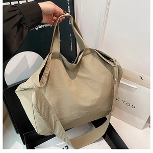 Dettaglio della grande borsa tote in nylon kaki con tracolla larga e trama tessile