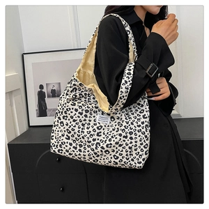 Detail of the leopard print canvas tote bag with a white fashion label and beige lining