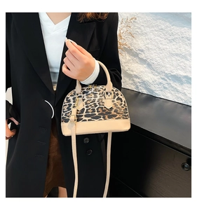 Detailed close-up of shell crossbody bag with leopard print and beige leather trim