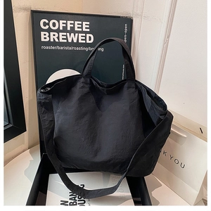 Dettaglio della grande borsa tote in nylon nero stropicciato in confezione regalo