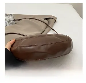 Detail of the durable bottom base and fine stitching on a brown matte leather bag