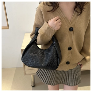 Detail view of the black textured leather hobo shoulder bag styled with an elegant outfit
