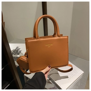 Detail of a brown PU leather shoulder bag with a round coin pouch and top handles