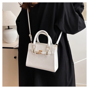White faux leather crossbody bag detail with golden buckle and adjustable strap
