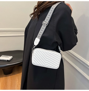 Détail du sac bandoulière matelassé blanc avec large sangle en tissu à motif en V