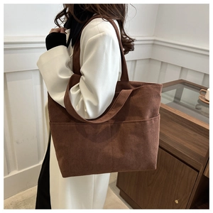 Detail einer großen braunen Cord-Tasche mit vertikaler Rippstruktur und praktischer Fronttasche