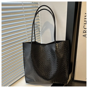Detail of the black faux-crocodile leather texture on a stylish shoulder tote bag