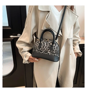 Detail of leopard print shell bag worn with a beige trench coat for a stylish look