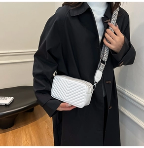 Détail du sac bandoulière blanc matelassé avec une large sangle à motif géométrique