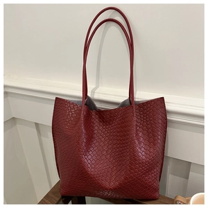 Detail of red woven texture leather tote bag with large capacity for daily commuting