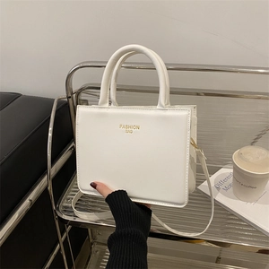 Chic white square tote bag with gold lettering and adjustable strap for daily commute