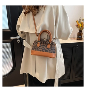 Fashionable leopard print shell bag with brown leather base and adjustable shoulder strap