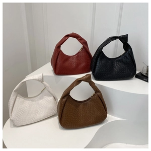 Detail of four colorful hobo bags with woven texture and knotted handles on display