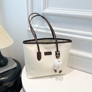 Large cream plaid tote bag with brown handles and fluffy monster charm for daily commute