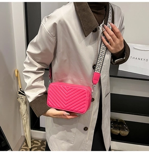 Détail du sac photo rose matelassé avec une large bandoulière tissée pour femmes