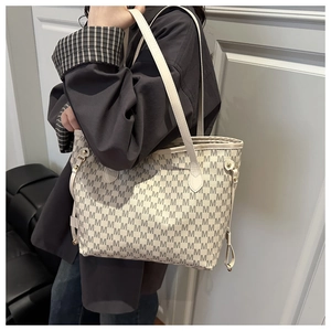 Detail view of large tote bag with M-print pattern worn by a model on shoulder