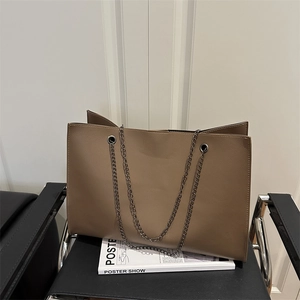 Borsa tote marrone in finta pelle con tracolla a catena d'argento su sfondo moderno