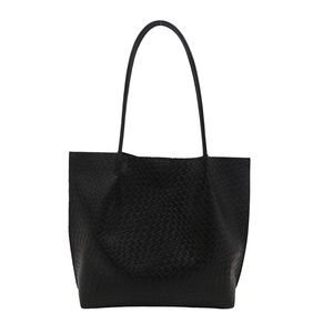 Large black woven tote bag with a minimalist design and long shoulder straps on white background
