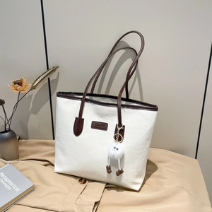 White quilted tote bag with brown straps and cute fur pom pom for daily commute